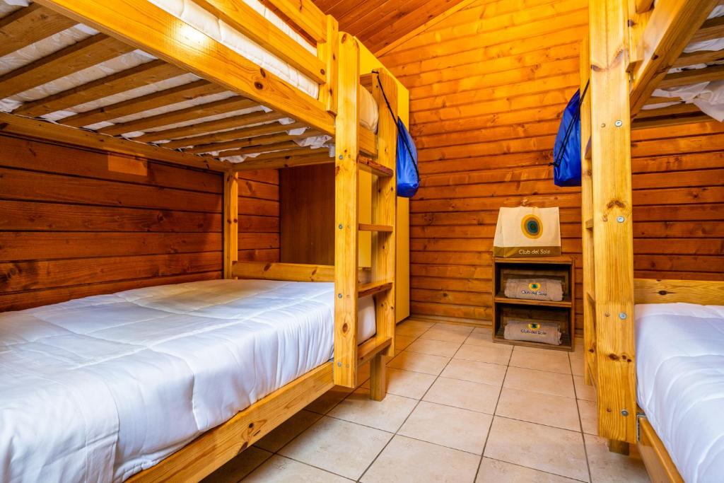 two bunk beds in a wooden room with a tv at Club del Sole Viareggio Family Collection in Torre del Lago Puccini