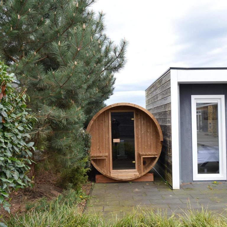 a wooden tub sitting on the side of a house at Ravenbosch - Sauna in Valkenburg