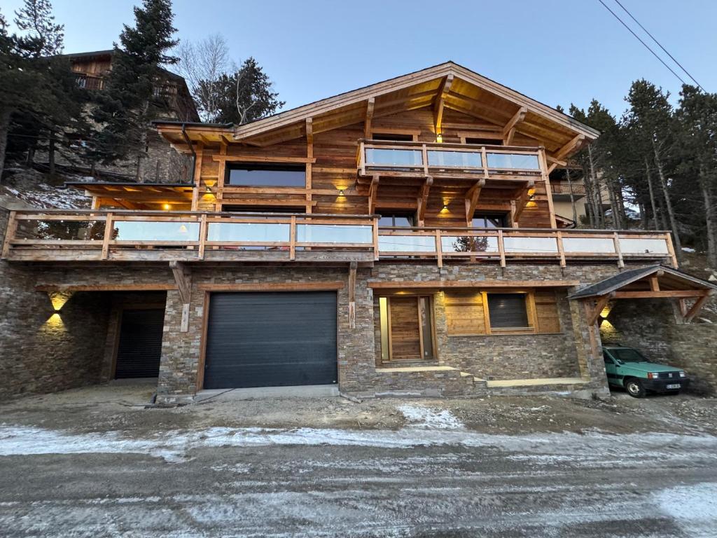 a wooden house with a balcony and a garage at Chalet Mélèzes in Les Angles