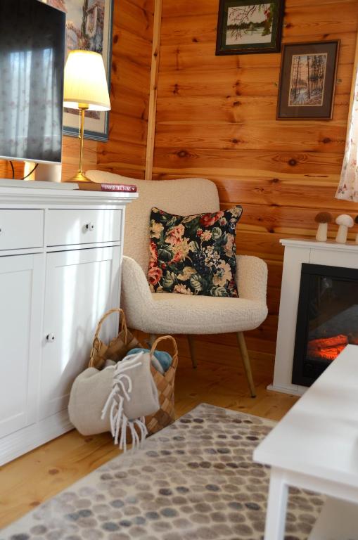 a living room with a chair and a fireplace at The Village Cottage in Natsovtsi