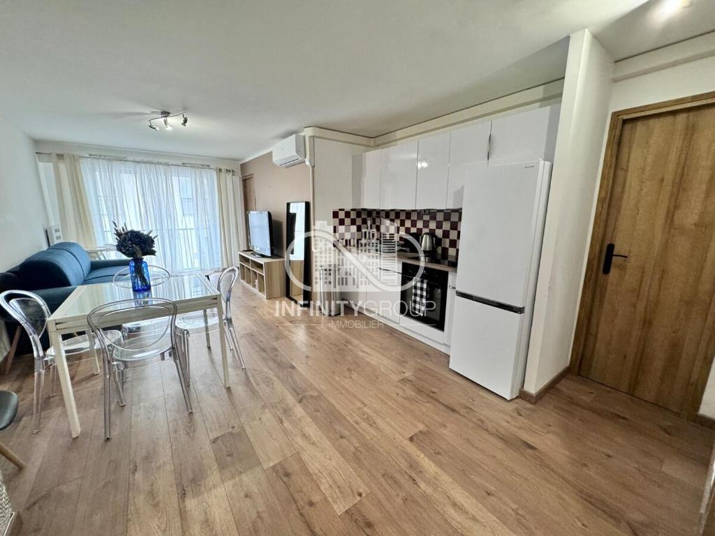 une cuisine et une salle à manger avec une table et un réfrigérateur dans l'établissement Appartement idéal famille - Centre-ville Juan-les-Pins, à Antibes