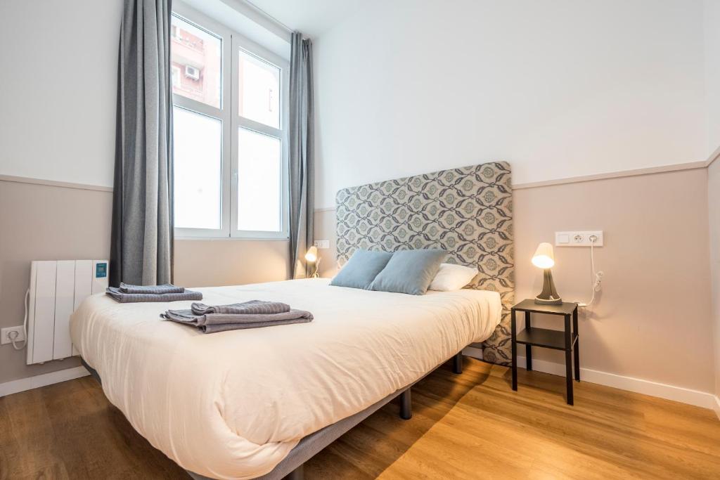 Hotel Coqueto 2H y 1B Delicias y Madrid Rio A, a bedroom with a bed with a large window at Coqueto 2H y 1B Delicias y Madrid Rio A in Madrid