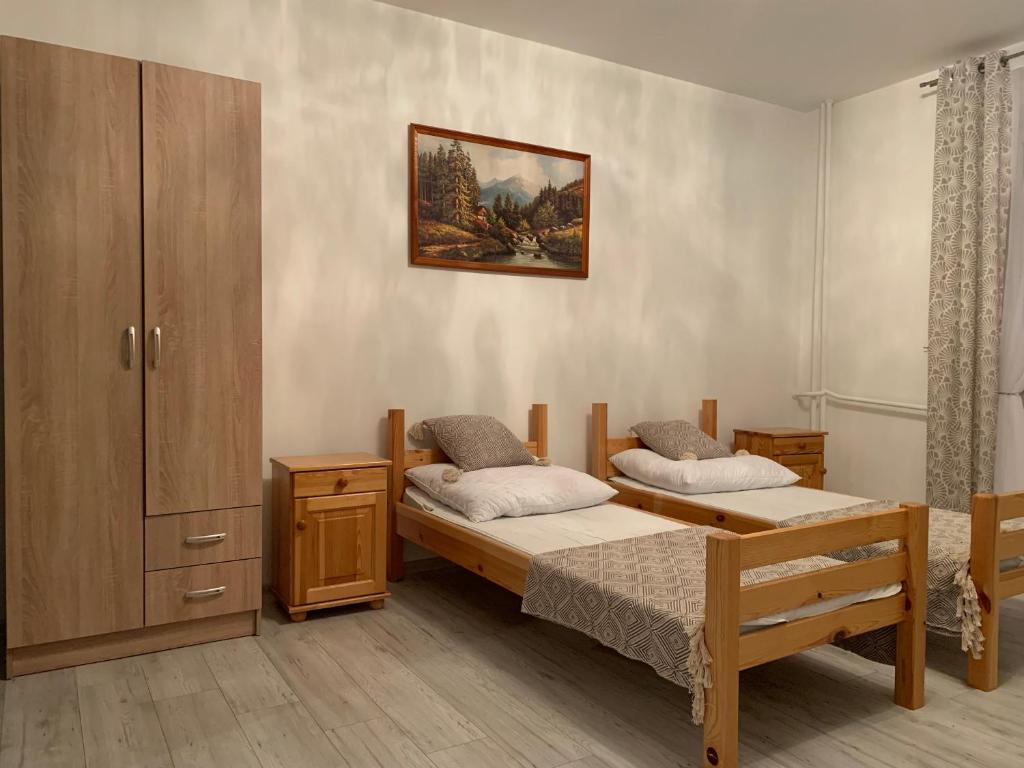 Zubrzyca DolnaAgroturystyka Pod Dzwonnicą - Babia Góra的一间卧室配有两张床和橱柜