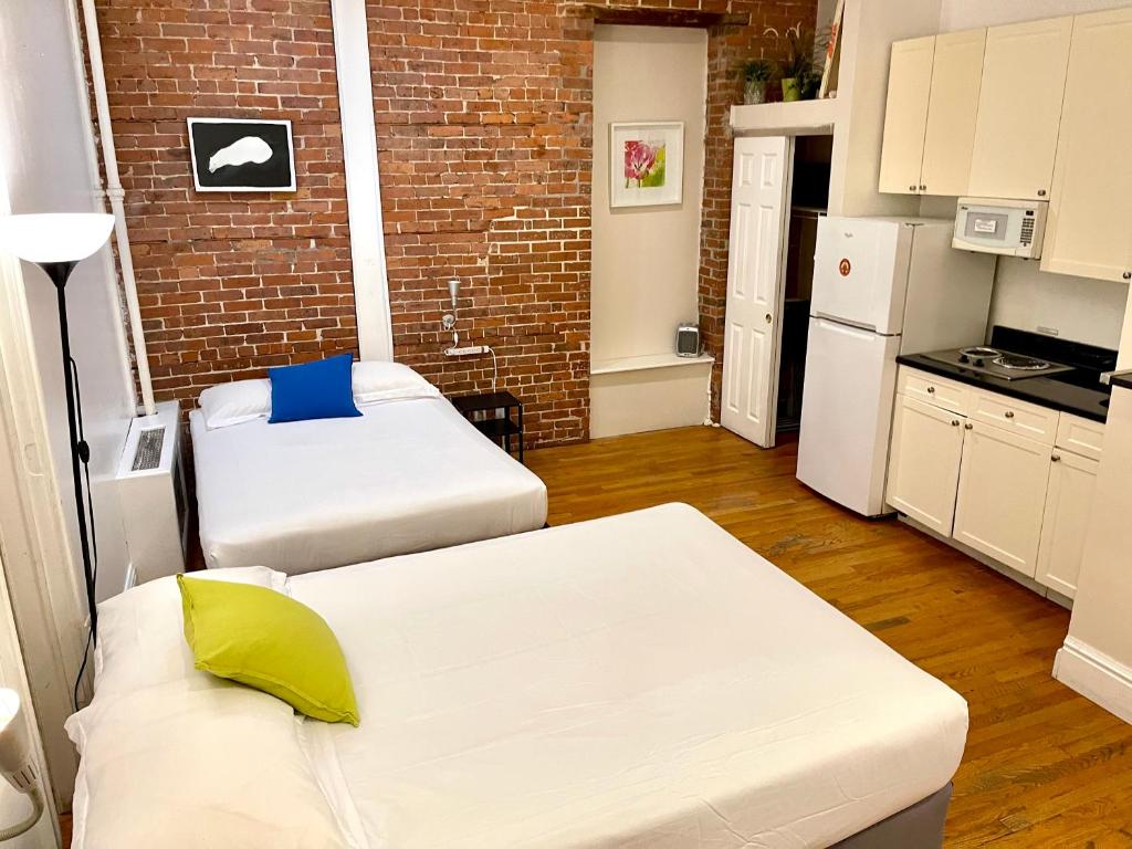 ein kleines Zimmer mit zwei Betten und einer Ziegelwand in der Unterkunft Nest Family Aparthotel - No Window in New York