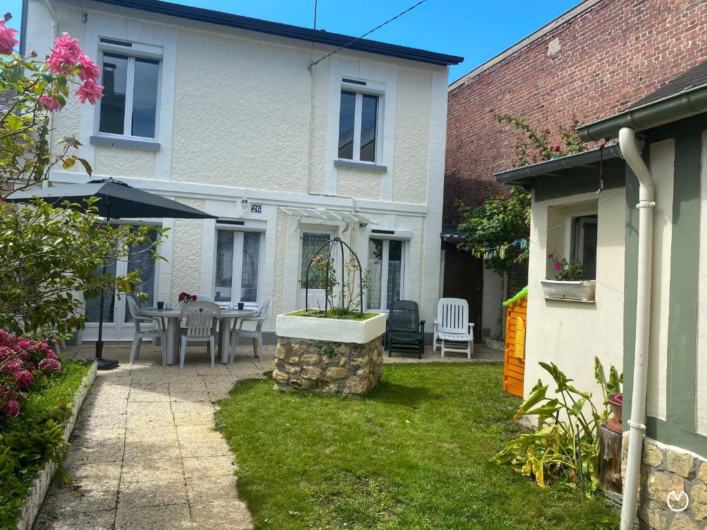 une maison avec un patio avec une table et des chaises dans l'établissement Maison Deauvillaise, à Deauville