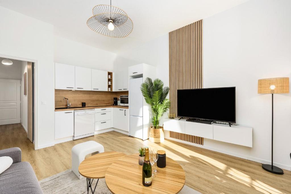 Il dispose d'une cuisine et d'un salon avec une table et une télévision. dans l'établissement JARDIN DES MUSES II - Somptueux 2 pièces - Carré d'or Menton, à Menton
