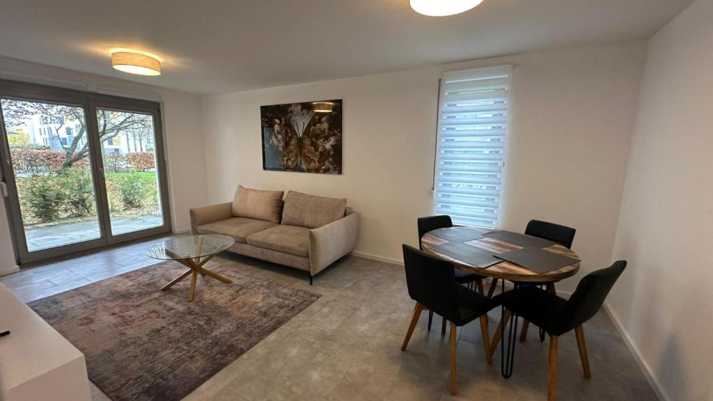 a living room with a table and chairs and a couch at Ruhige Wohnung mit Garten in Schönefeld