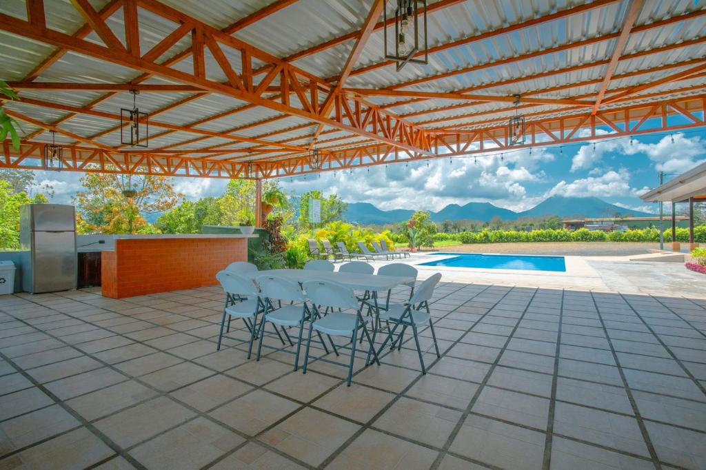 a patio with a table and chairs and a pool at Casa vacacional cerca de la Fortuna San Carlos in Tanque