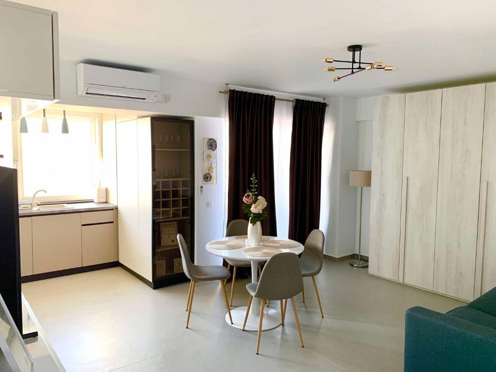 a living room with a white table and chairs at Oltenia Studio Decebal Residence Craiova in Craiova