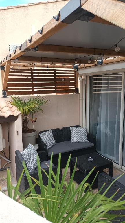 d'une terrasse avec un canapé et une table. dans l'établissement Pavillon 4/6 pers. 30 m² Gruissan Les Ayguades, à Gruissan
