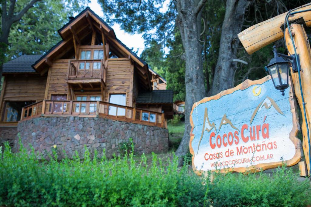 una señal frente a una cabaña de madera en Cocos Cura Casas de montaña en San Carlos de Bariloche