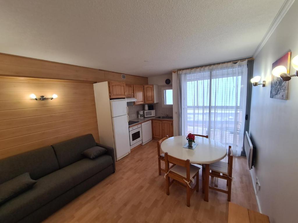 un salon avec un canapé et une table et une cuisine dans l'établissement ETOILE DES NEIGES, à Orcières