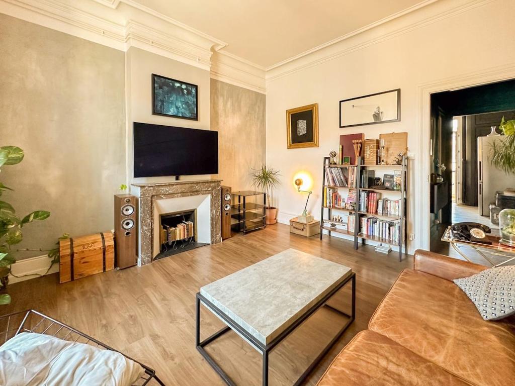 un salon avec un canapé et une cheminée dans l'établissement Palma - charmant T3 dans le centre historique, à Montpellier