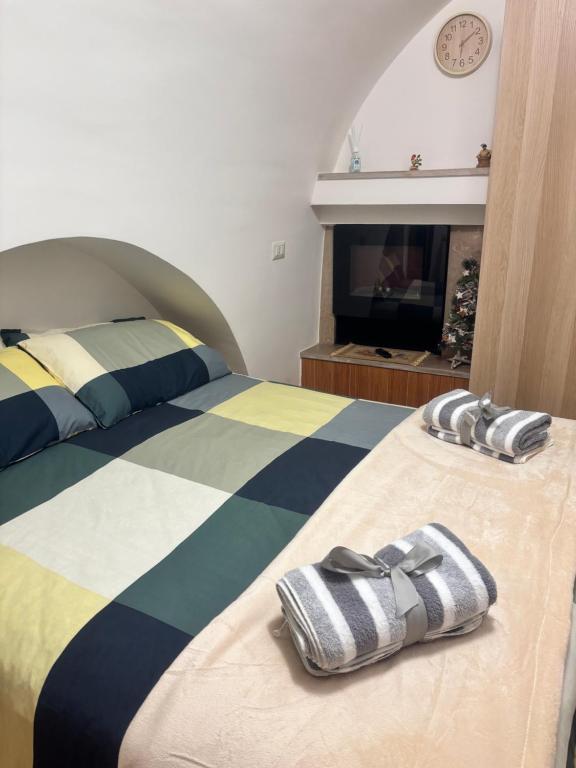 ein Schlafzimmer mit einem Bett mit zwei Hausschuhen darauf in der Unterkunft Santa Lucia in Rutigliano