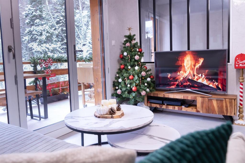 a living room with a christmas tree and a fireplace at Studio cabine Au Loup Blanc avec vue Mont Blanc in Saint-Gervais-les-Bains