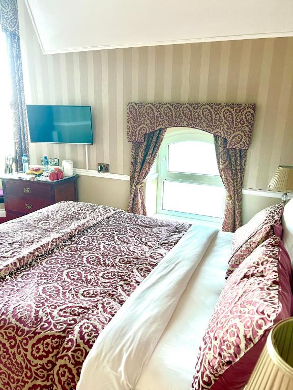 a bedroom with a bed with a red and white bedspread at Albany Lodge in Portrush