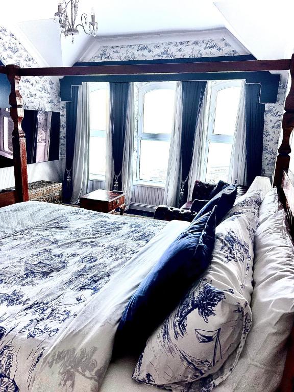 a bedroom with a large bed with blue and white pillows at Albany Lodge in Portrush