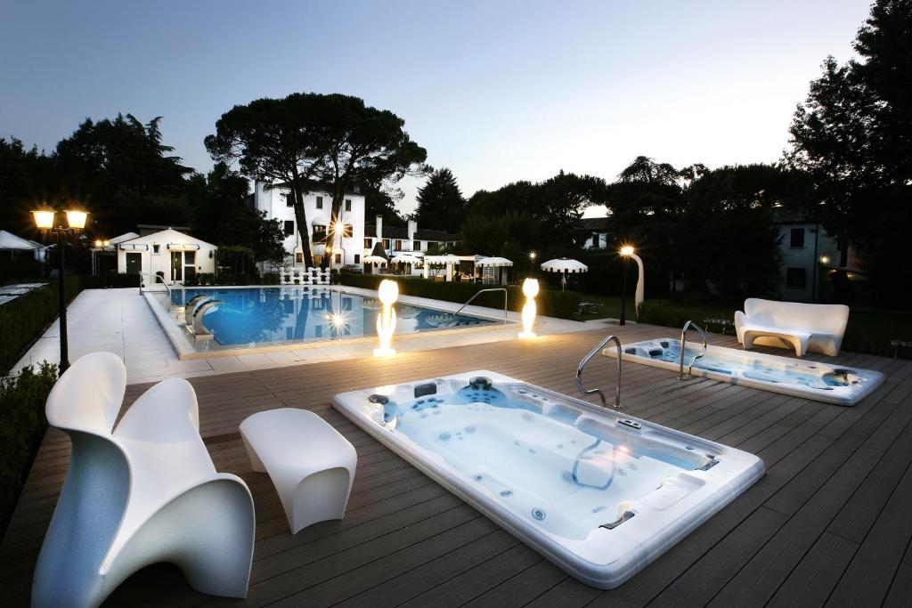 a hot tub sitting on a deck next to a pool at Park Hotel Villa Giustinian in Mirano