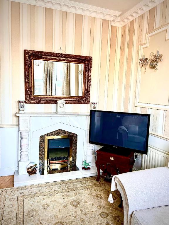 a living room with a television and a fireplace at Albany Lodge in Portrush