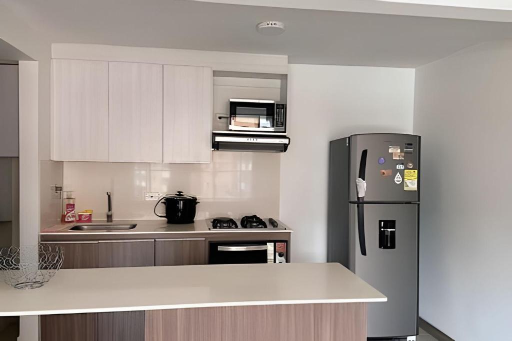 una cucina con frigorifero e piano di lavoro di Moderno Apartamento Sabaneta- Century Tower II a Envigado