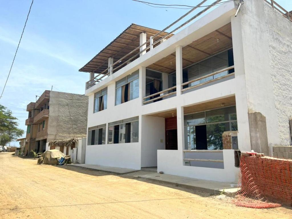 un grand bâtiment blanc au bord d'une rue dans l'établissement Casa de Playa - Punta Sal, à La Bocana