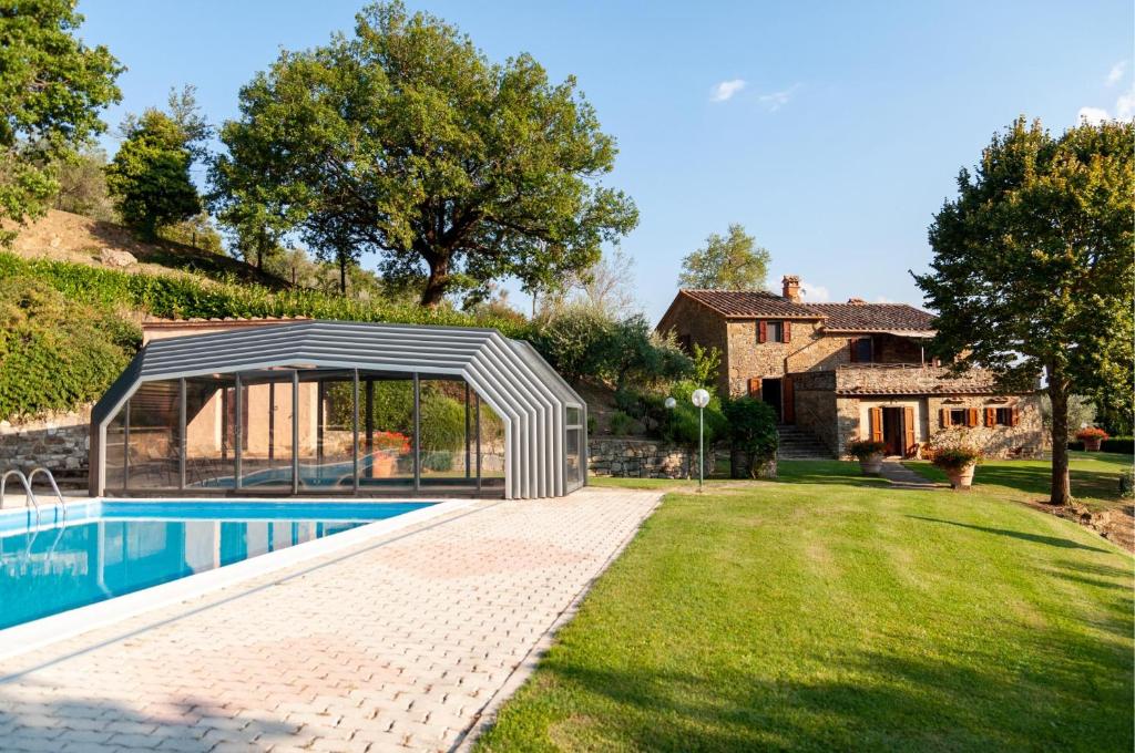 a swimming pool with a pavilion next to a house at Villa Beatrice - Private Heated Pool & Amazing Umbrian Landscape in Corgna