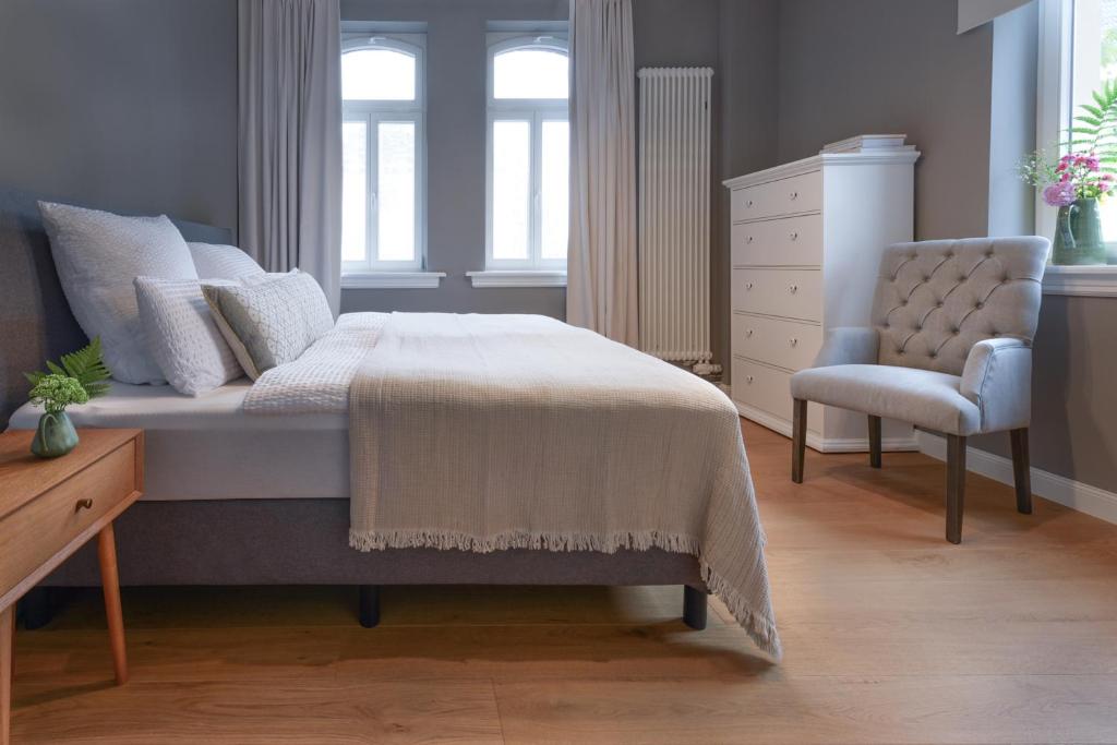 una camera con letto, sedia e cassettiera di Am Renngraben 1 - Wohnen auf Zeit a Limburg an der Lahn