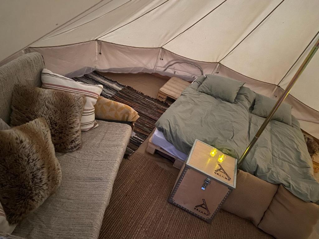 een slaapkamer met een tent met een bank en een laptop bij Foskvallen Lodge in Särna