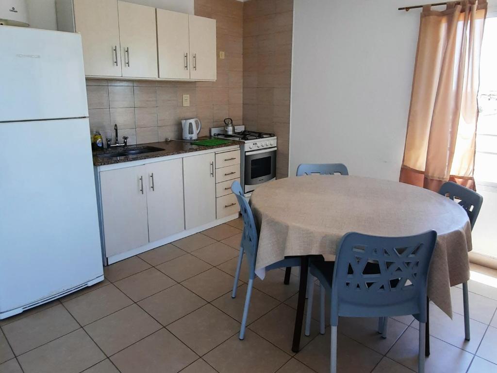 una cucina con tavolo, sedie e frigorifero bianco di SyS Departamento a Federación