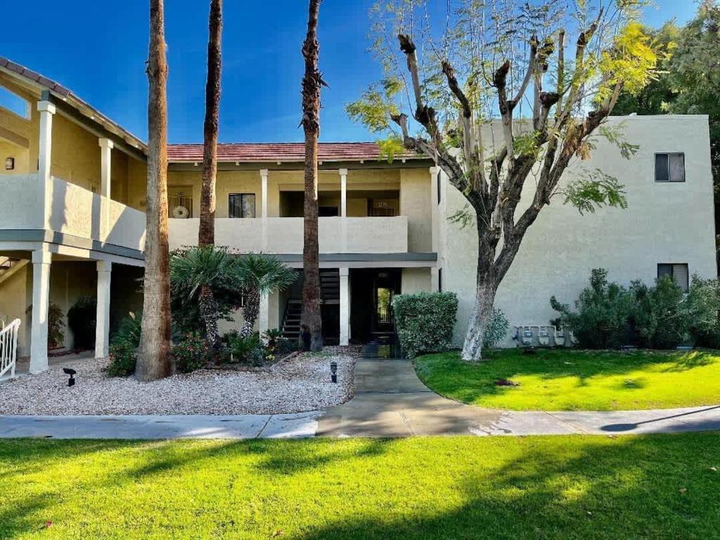 an exterior view of a house with palm trees at 2BD Ground Floor Condo in Gated Gardens Pool&Spa in Palm Springs