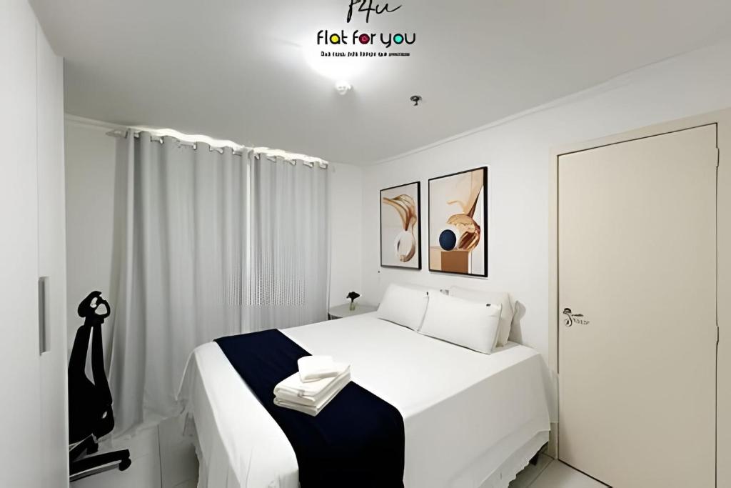 a white bedroom with a large white bed and a window at #1806A# - Apto 1 quarto- Metropolitan Barcelona in Goiânia