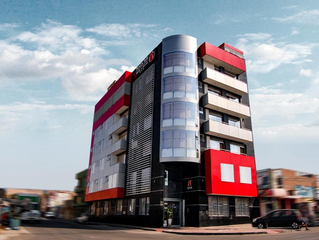 タクナにあるPlaza Sur Hotel & Suitesの市道の赤白の建物