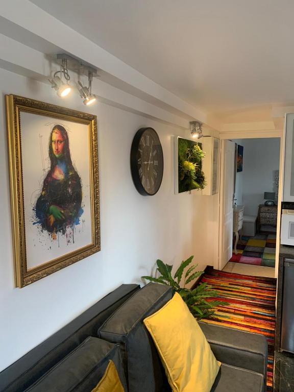 un salon avec un canapé et une horloge au mur dans l'établissement Appartement DJAhyane, à Champigny-sur-Marne