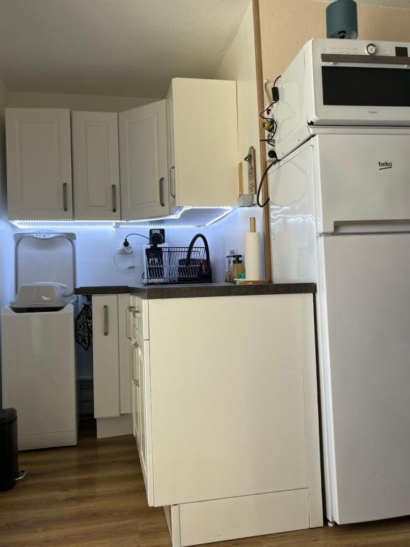 une cuisine avec des armoires blanches et un réfrigérateur blanc dans l'établissement Appartement t2, à Fleury