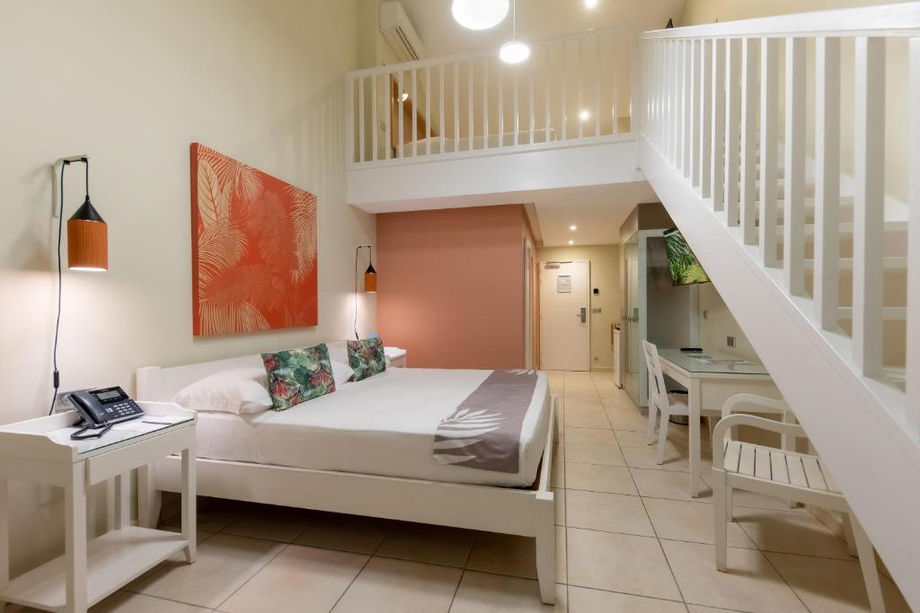 una camera con letto e scala di La Pagerie - Tropical Garden Hotel a Les Trois-Îlets