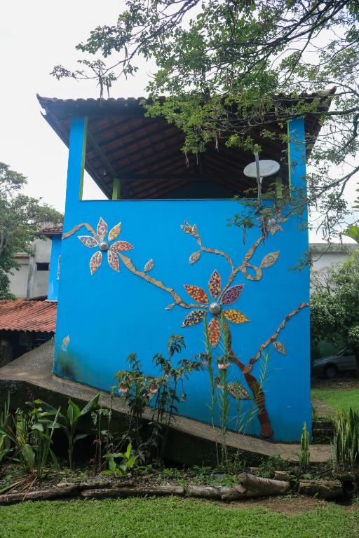 a blue building with a tree painted on it at Sobrado da Casa Azul - Penedo in Itatiaia
