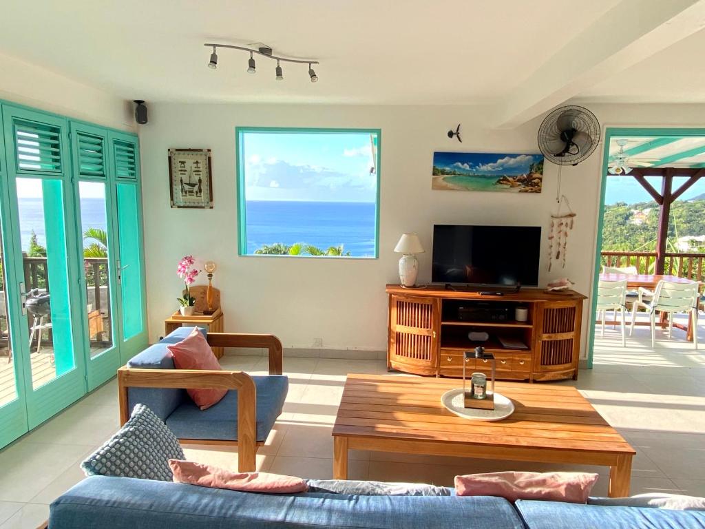 TV a/nebo společenská místnost v ubytování Espace Harmonie Deshaies - Vue Mer & Piscine Panoramique