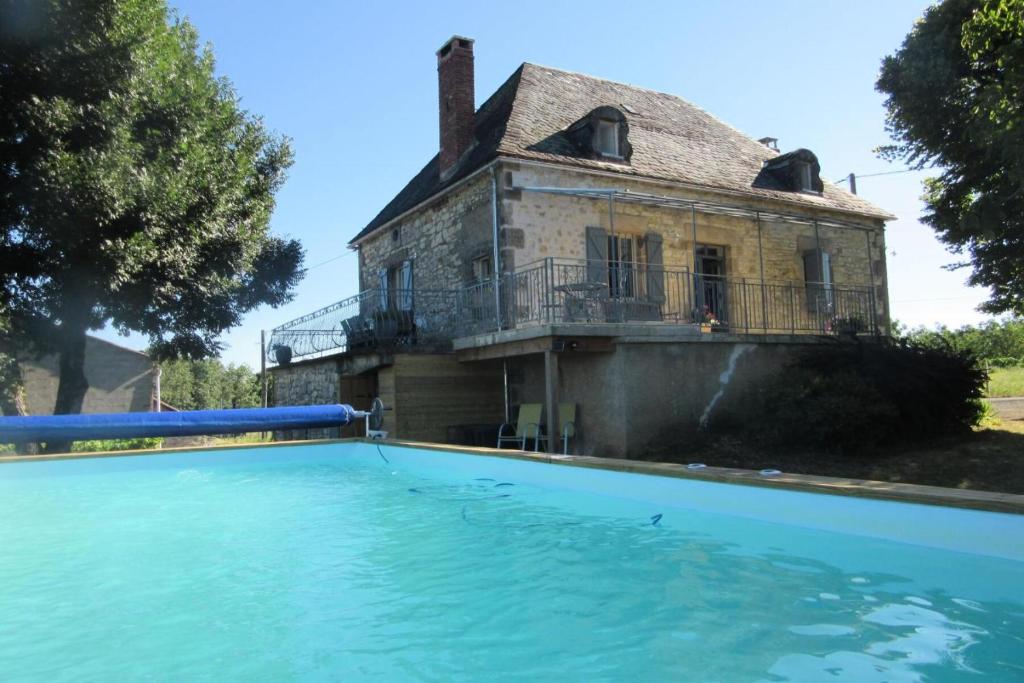 an old house with a swimming pool in front of a house at Gîte de France Belleviste 3 épis - Gîte de France 10 personnes MAE-1521 in Queyssac-les-Vignes