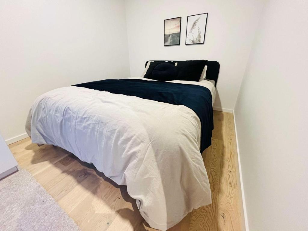a bedroom with a large bed with white sheets at Seaside seaview apartment in Tromsø