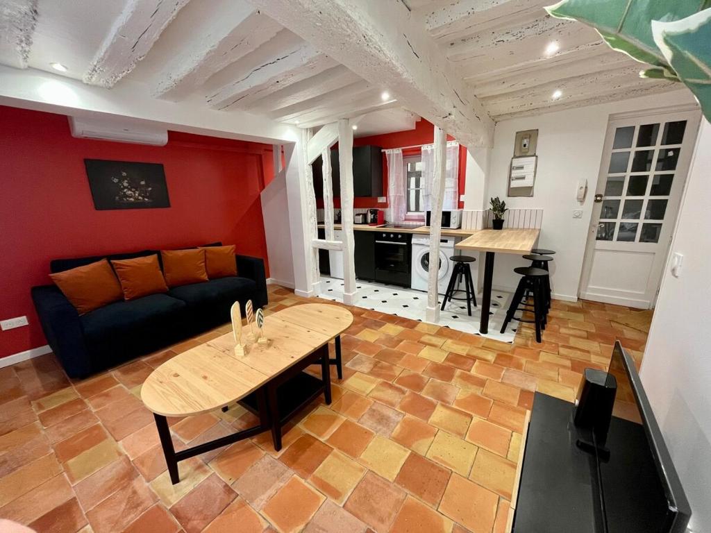 un soggiorno con un divano e un tavolo di l'Hibiscus a Rouen