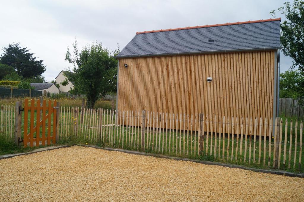 une clôture en bois à côté d'un bâtiment en bois dans l'établissement MORGREVE Ty Pic, à La Vicomté-sur-Rance