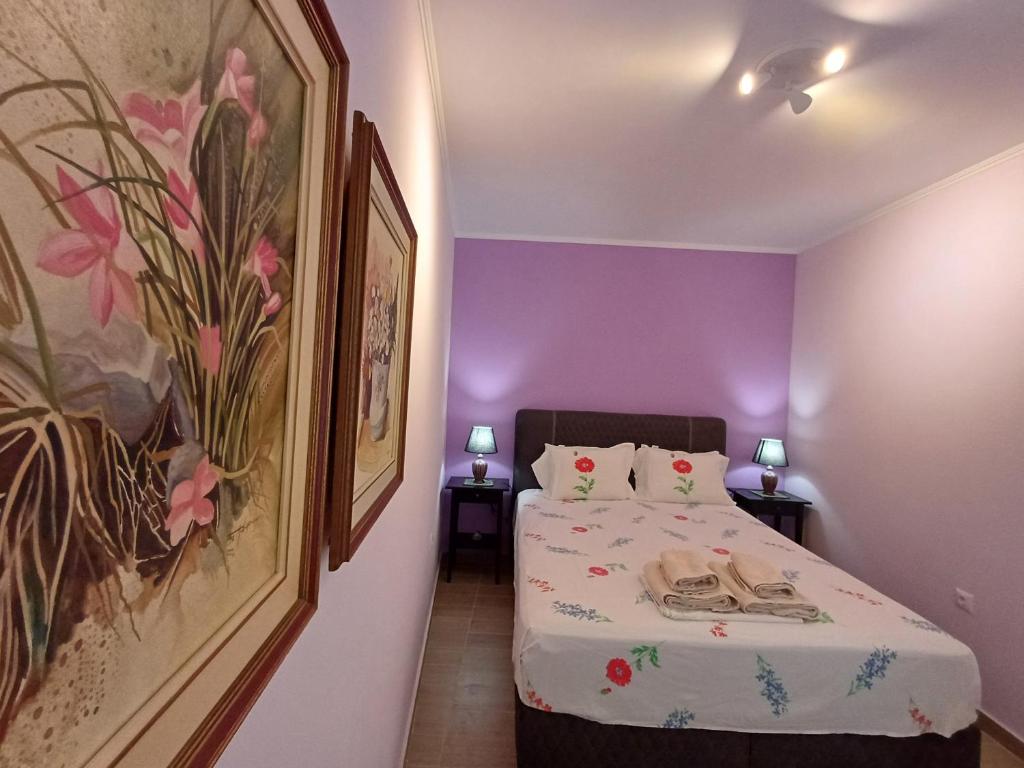 a bedroom with a bed with a painting on the wall at Athinas Residence in Myrina