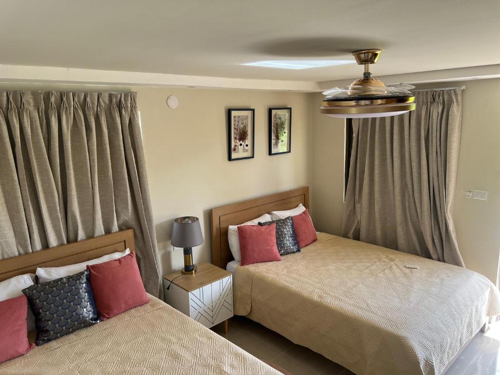 Un dormitorio con dos camas y una ventana. en Soficu Hotel El Edén Dominicus, en Bayahibe