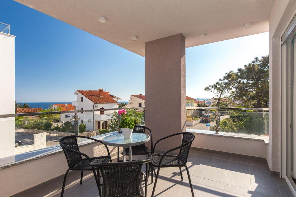 a balcony with a table and chairs and a view of the ocean at Apartments Stella in Krk