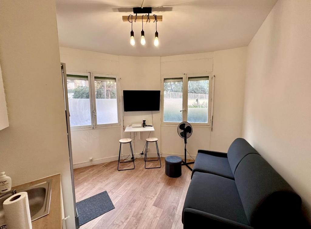 Il comprend un salon doté d'un canapé et d'une télévision. dans l'établissement Jolie chambre équipée proche vélodrome mer, à Marseille