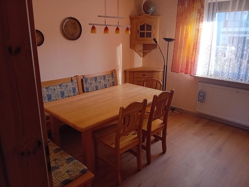 a wooden table and chairs in a room with a table at Business und Messe Apartment TULPE in Zirndorf