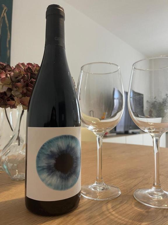 a bottle of wine with an eye on it next to two glasses at Ruavieja, camino y vino in Logroño