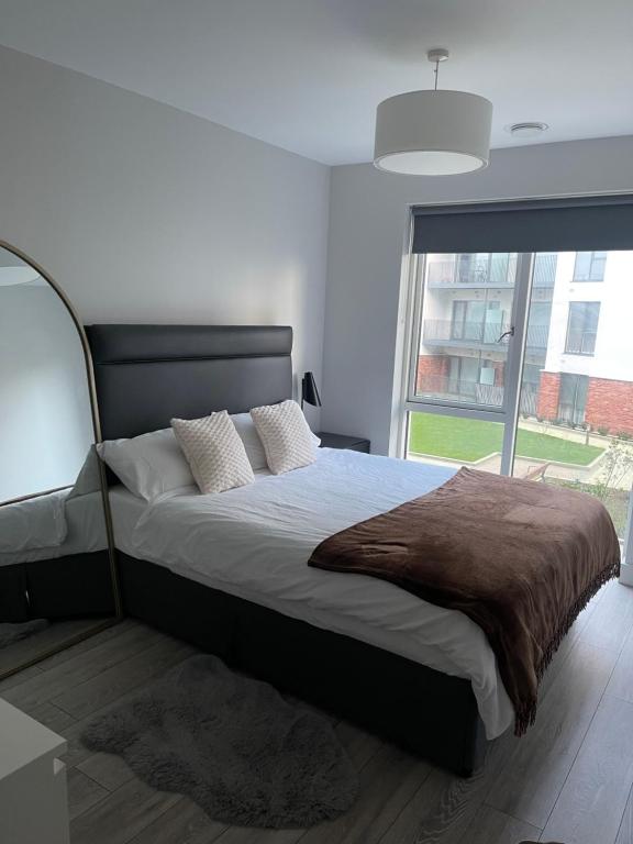 una camera da letto con un letto grande con una grande finestra di Cozy room in a shared apartment a Lucan