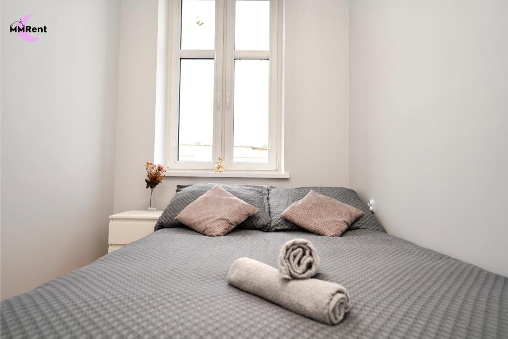 a bedroom with a bed with two pillows and a window at MMRent Manhattan Room in Gdańsk