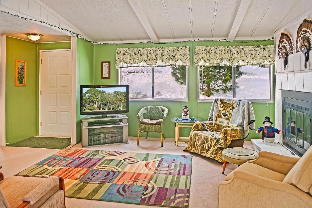 a living room with green walls and a television at Huckleberry Cabin in Dryden